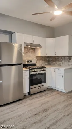 a kitchen with a stove a refrigerator and a sink