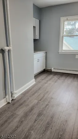 an empty room with wooden floor and window