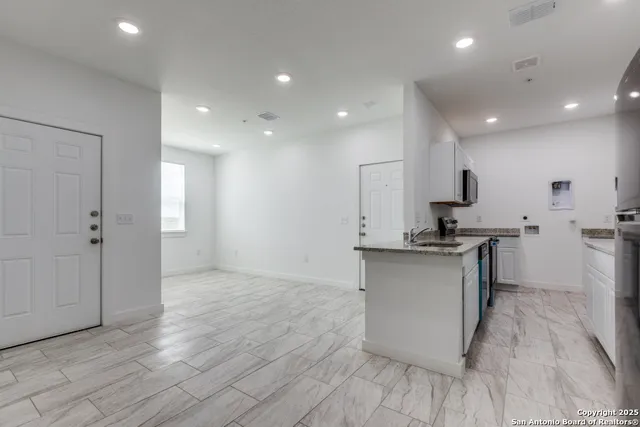 a kitchen with a sink cabinets and wooden floor