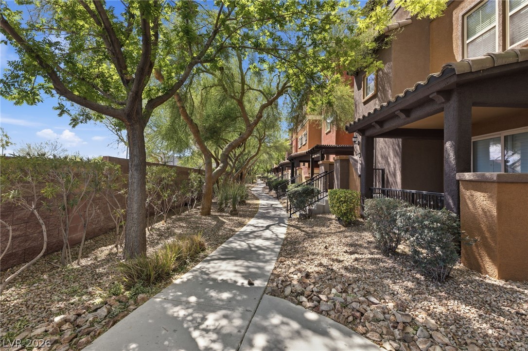 4650 Ranch House Road, Unit 126 North Las Vegas, NV 89031 - Photo 3 of 44 This inviting walkway leads to charming residences, framed by lush trees and manicured landscaping.
