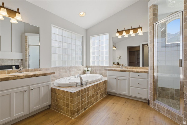 12317 Cypress Point Way Draper, UT 84020 - Photo 19 of 41 Mater Bathroom featuring a built-in jetted tub with tiled surround, a tiled walk-in shower with clear glass door, and dual vanities with integrated sinks and matching tiled countertops