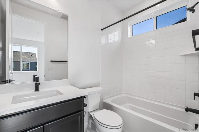 a bathroom with a sink toilet vanity and tub