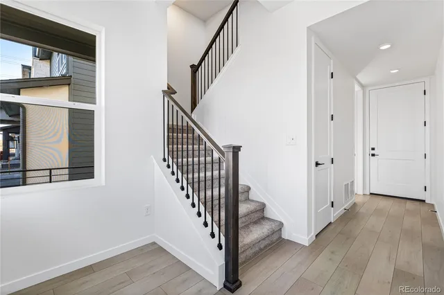 a view of hallway with stairs and wooden floor