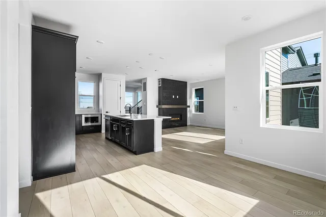 a large room with stainless steel appliances kitchen island granite countertop a refrigerator and a sink