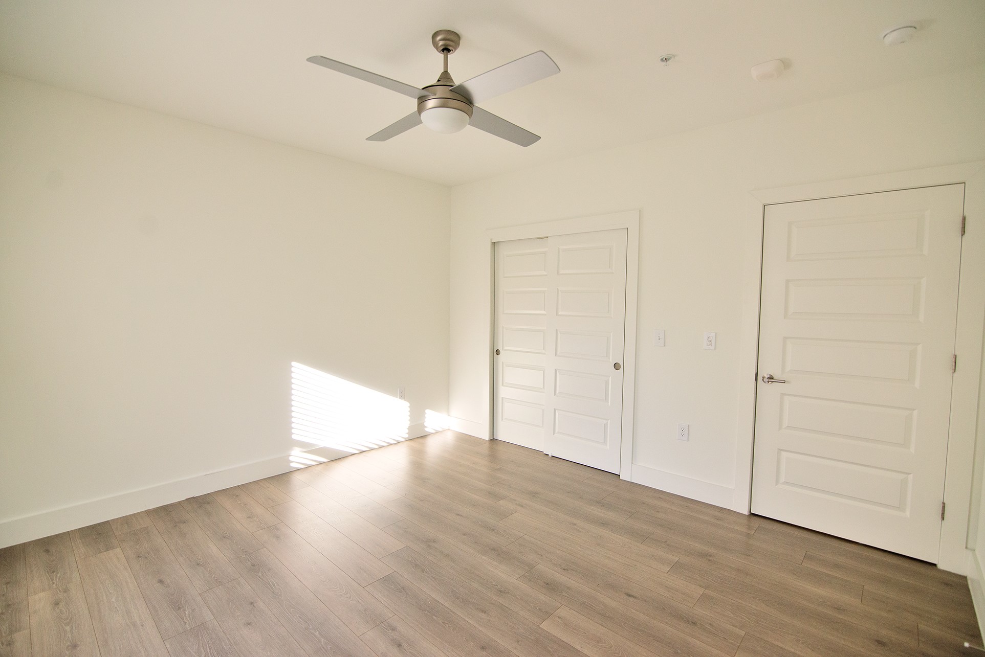 2213 Poquito Street, Unit 313 Austin, TX 78722 - Photo 11 of 26 an empty room with wooden floor ceiling fan and windows