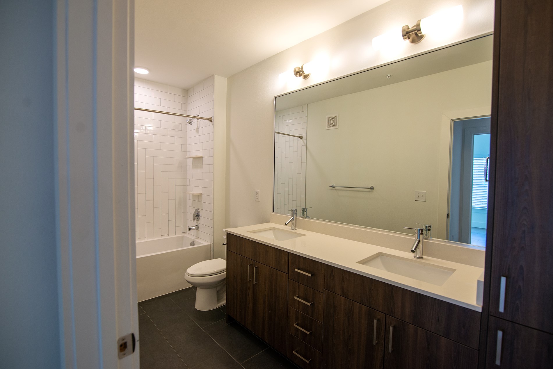 2213 Poquito Street, Unit 313 Austin, TX 78722 - Photo 12 of 26 a bathroom with a double vanity sink toilet mirror and shower