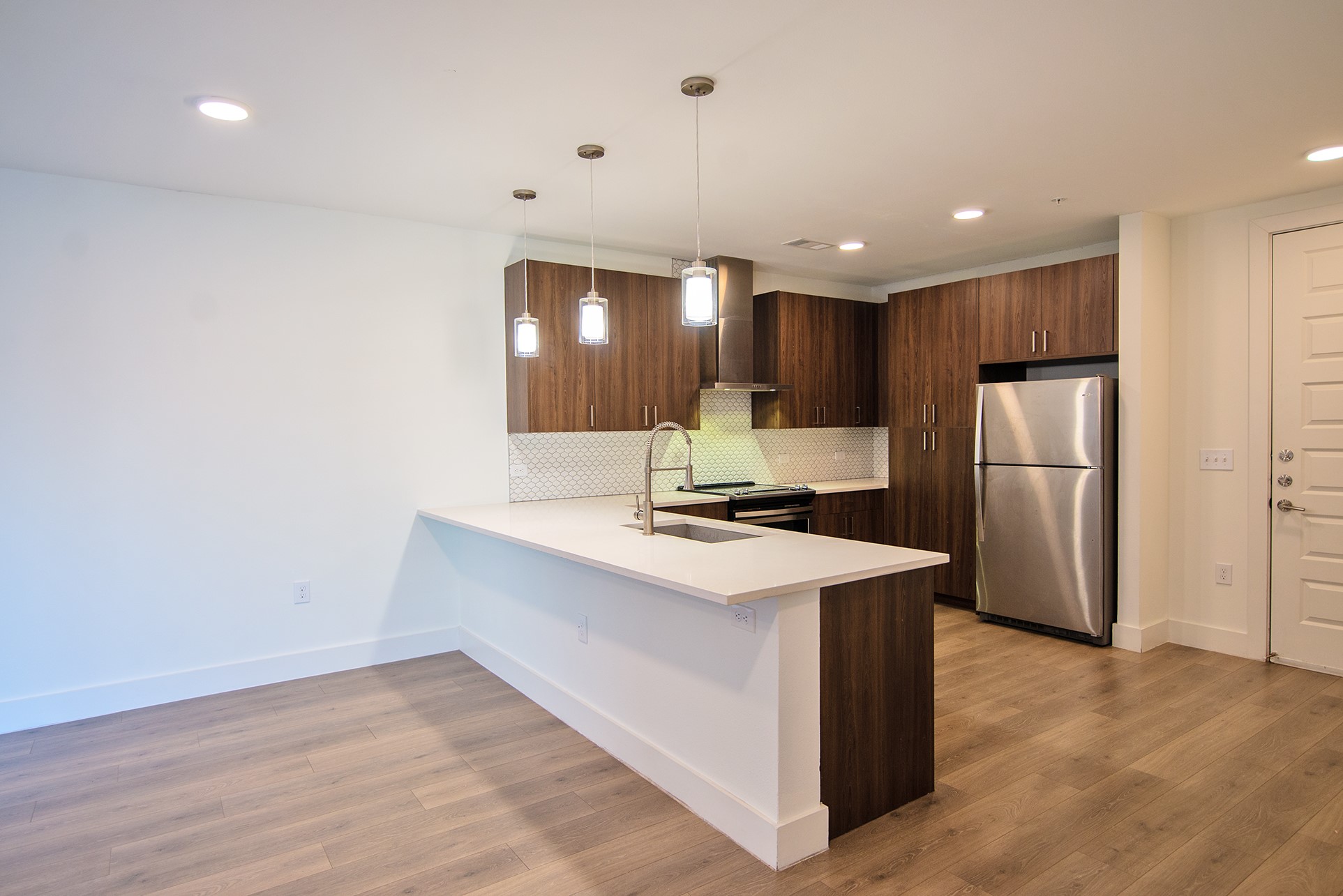 2213 Poquito Street, Unit 313 Austin, TX 78722 - Photo 2 of 26 a kitchen with a refrigerator a sink and a microwave