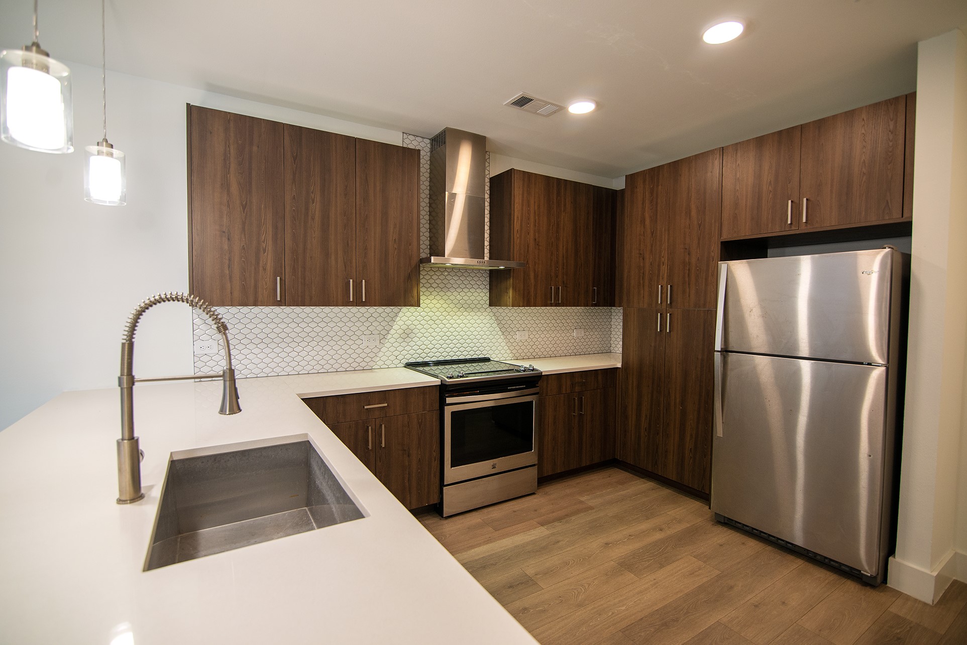 2213 Poquito Street, Unit 313 Austin, TX 78722 - Photo 4 of 26 a kitchen with kitchen island granite countertop wooden cabinets and stainless steel appliances