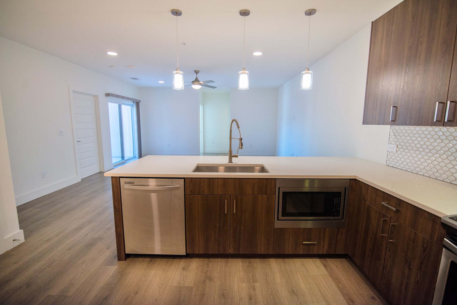 2213 Poquito Street, Unit 313 Austin, TX 78722 - Photo 8 of 26 a kitchen with kitchen island a sink dishwasher a stove and a wooden floor