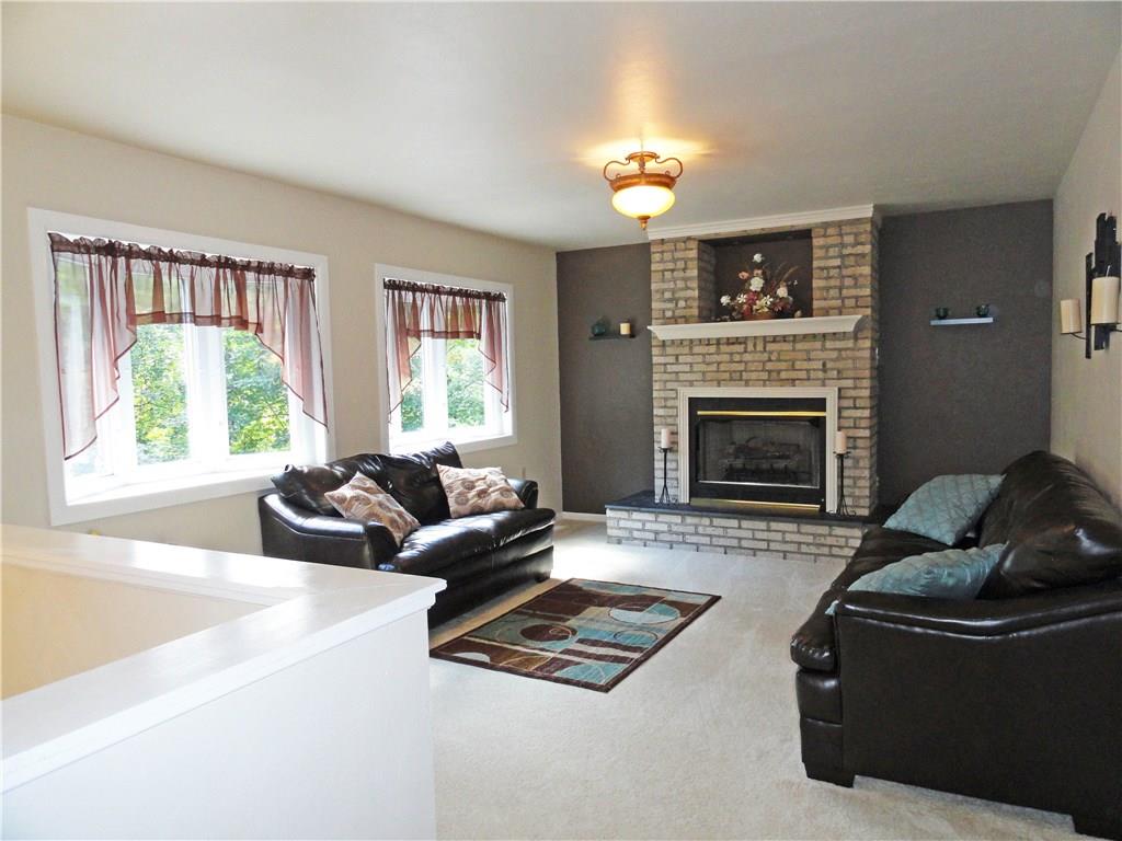 Large living room with double bow windows and brick fireplace