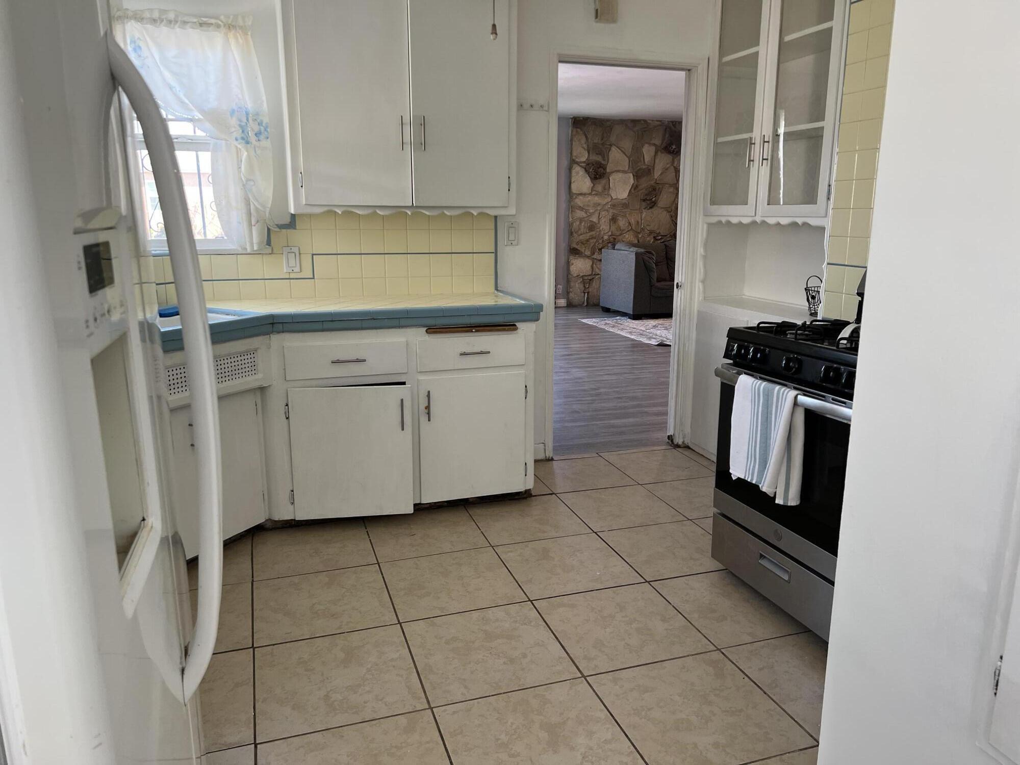 4916 Brompton Avenue Bell, CA 90201 - Photo 18 of 50 a kitchen with a stove a sink and a refrigerator