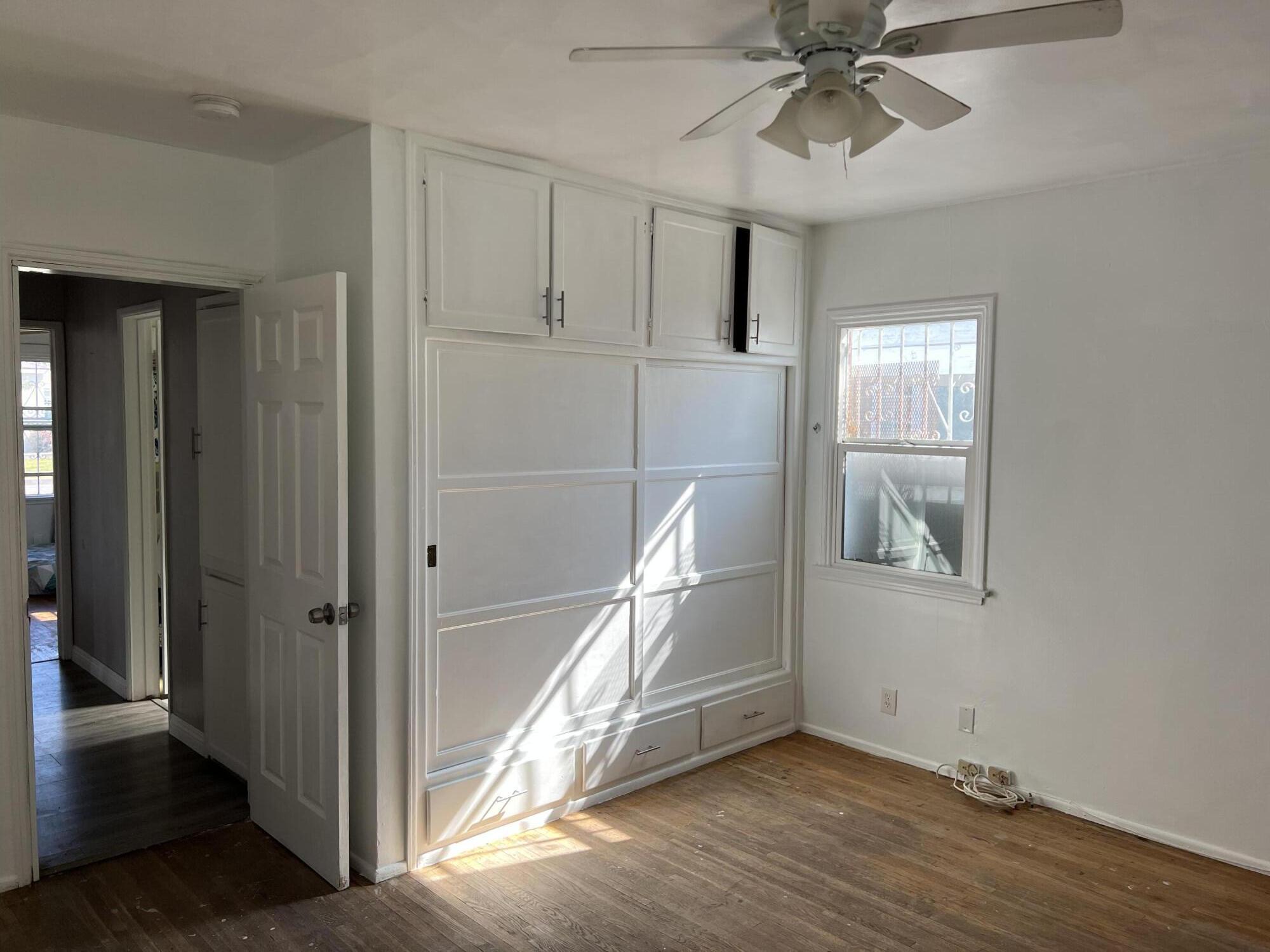 4916 Brompton Avenue Bell, CA 90201 - Photo 30 of 50 an empty room with wooden floor closet and windows