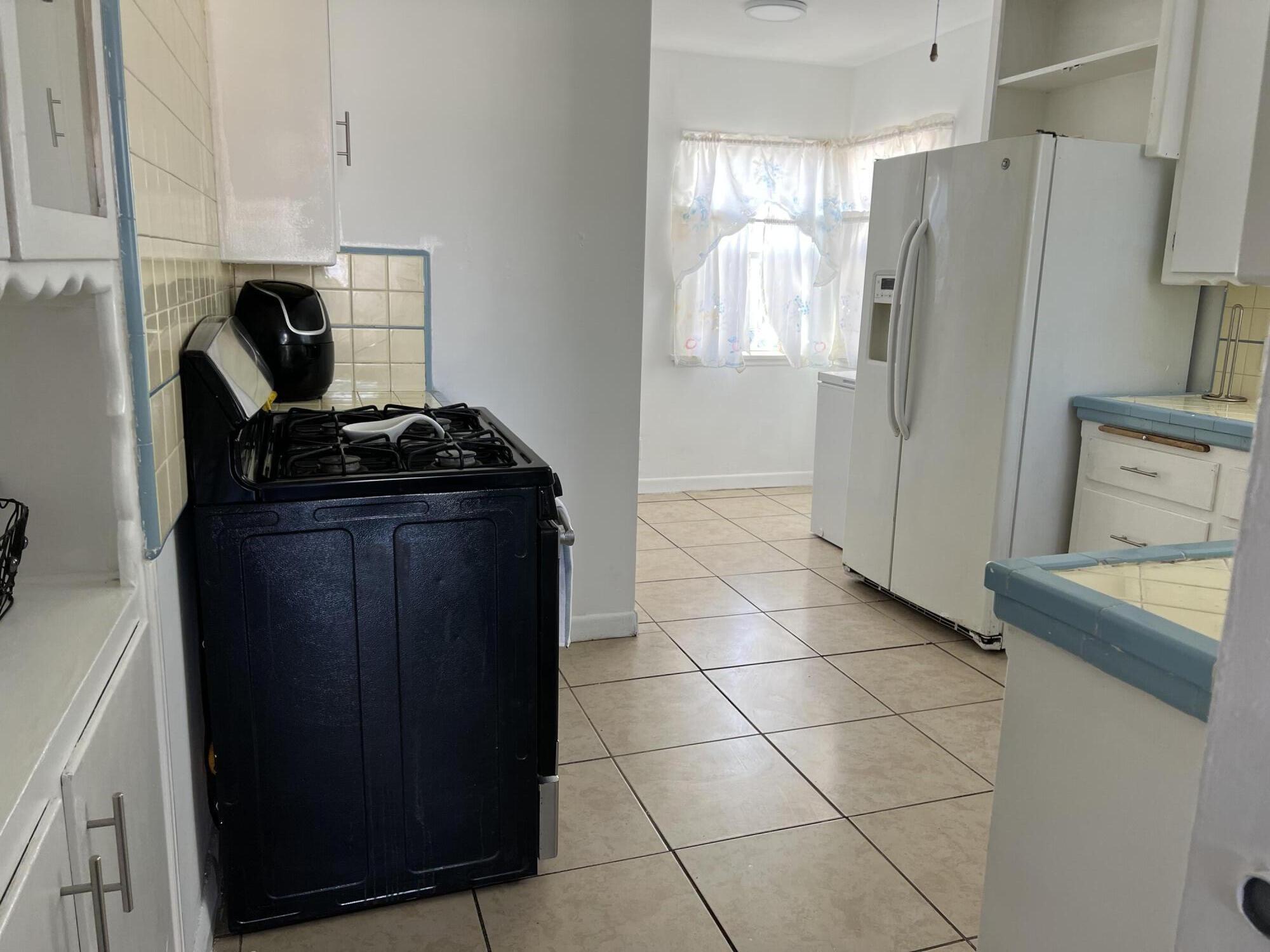 4916 Brompton Avenue Bell, CA 90201 - Photo 3 of 50 a kitchen with a refrigerator and a stove