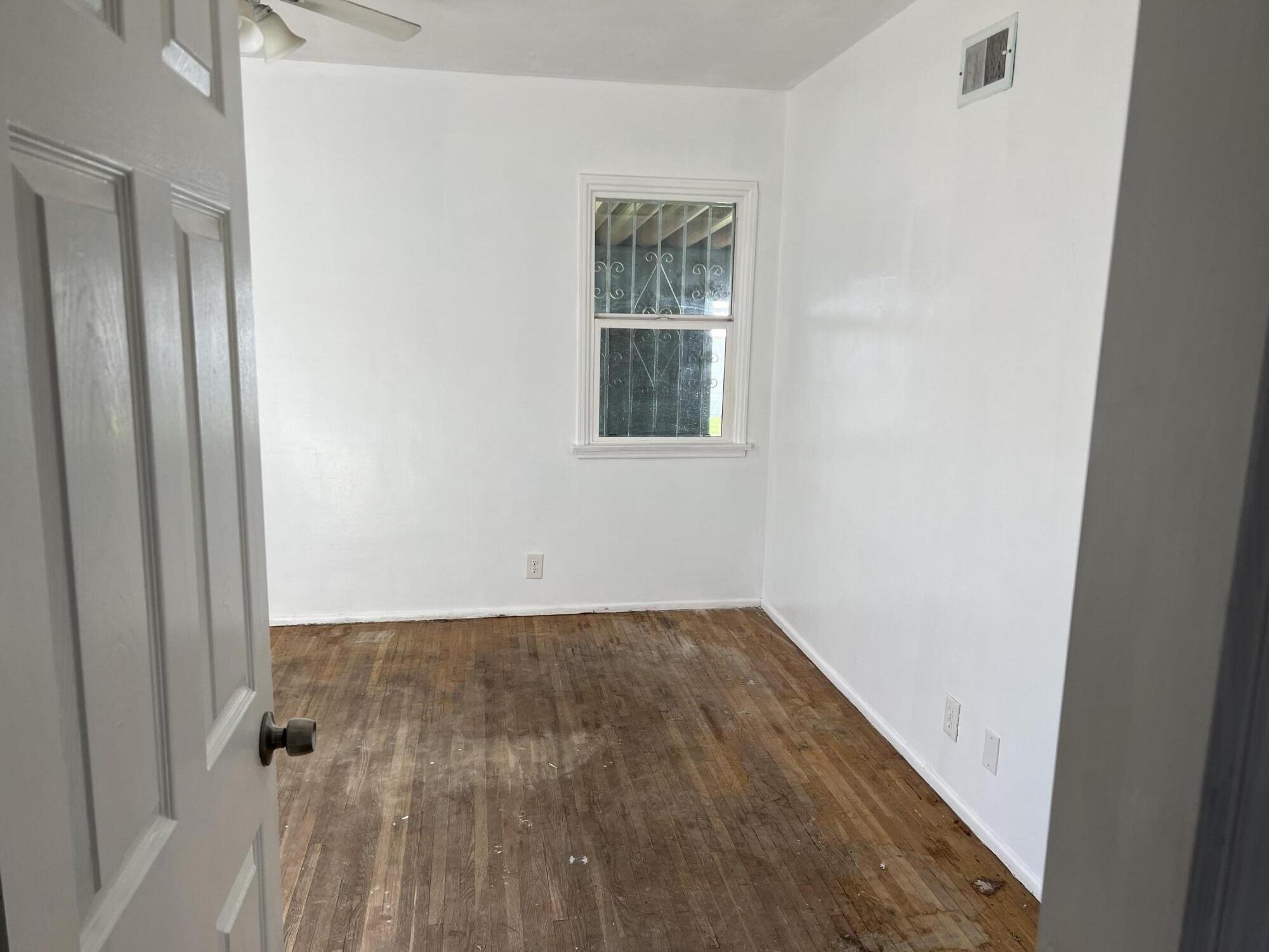 4916 Brompton Avenue Bell, CA 90201 - Photo 33 of 50 an empty room with wooden floor and a window