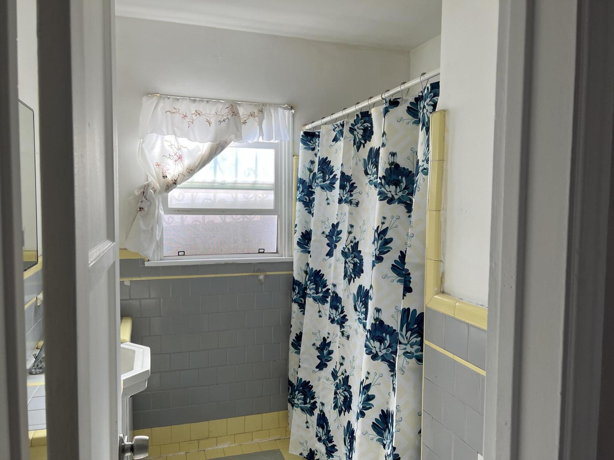 4916 Brompton Avenue Bell, CA 90201 - Photo 6 of 50 a bathroom with a window and a shower curtain