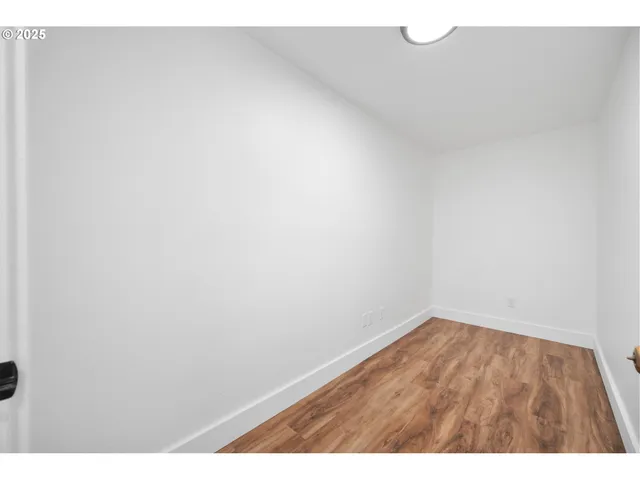 a view of an empty room and window with wooden floor