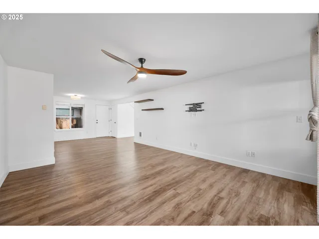 a view of empty room with wooden floor