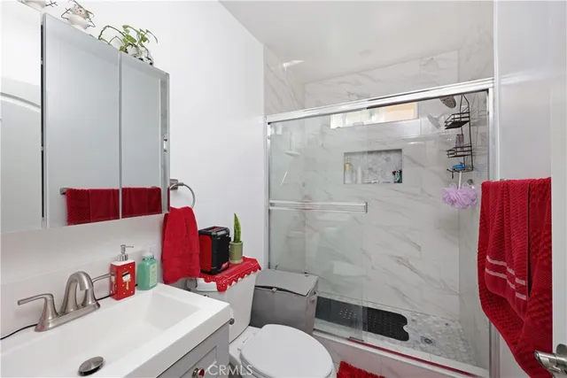 a bathroom with a sink toilet vanity and shower