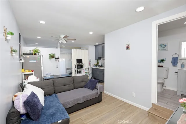 a living room with furniture and a view of kitchen
