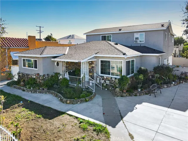a front view of a house with a yard and potted plants
