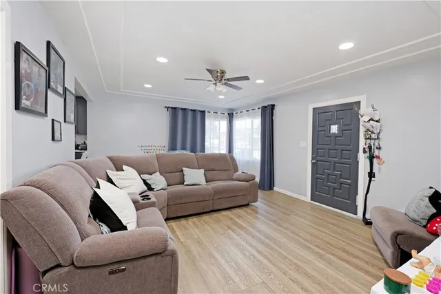 a living room with furniture and a ceiling fan