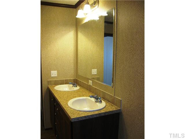 7309 Trouble Road Willow Spring, NC 27592 - Photo 12 of 22 a bathroom with a sink and a mirror