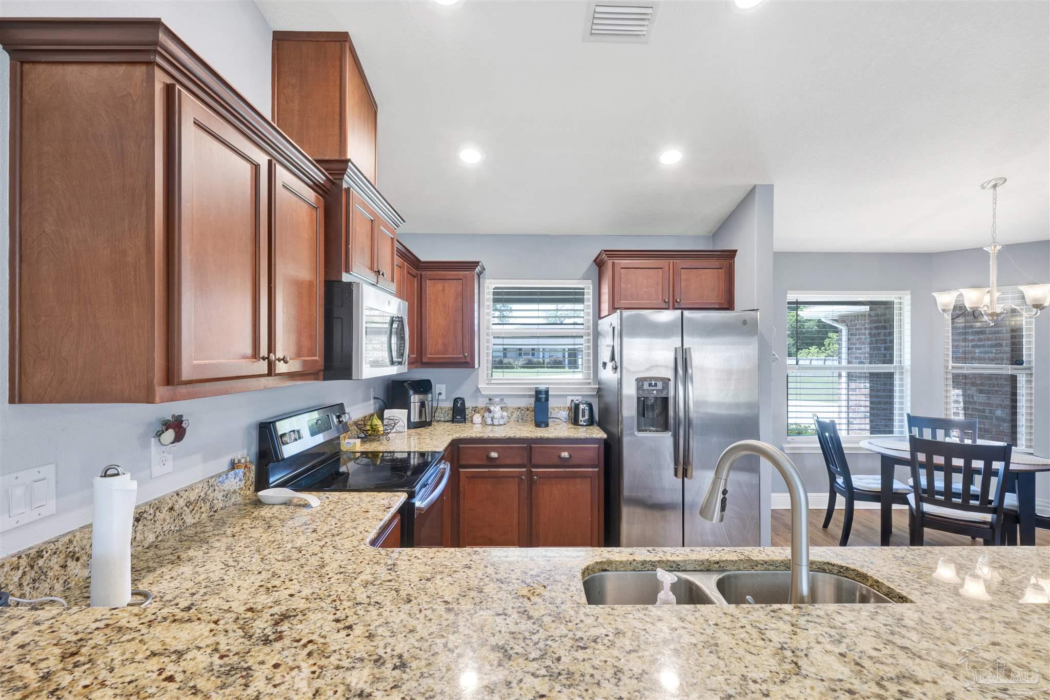 6336 Apple Ridge Circle Pensacola, FL 32526 - Photo 12 of 41 a kitchen with stainless steel appliances kitchen island granite countertop a refrigerator and a sink