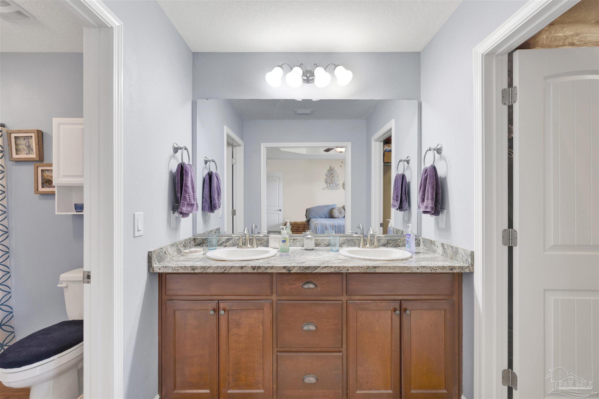 6336 Apple Ridge Circle Pensacola, FL 32526 - Photo 18 of 41 a bathroom with a granite countertop sink a toilet and a mirror