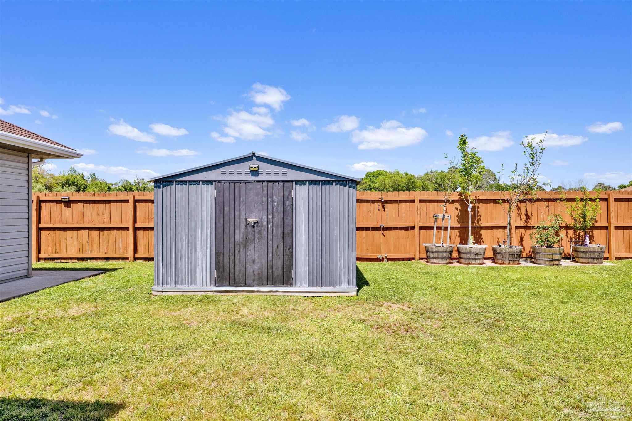 6336 Apple Ridge Circle Pensacola, FL 32526 - Photo 25 of 41 a view of a backyard with large tree and wooden fence