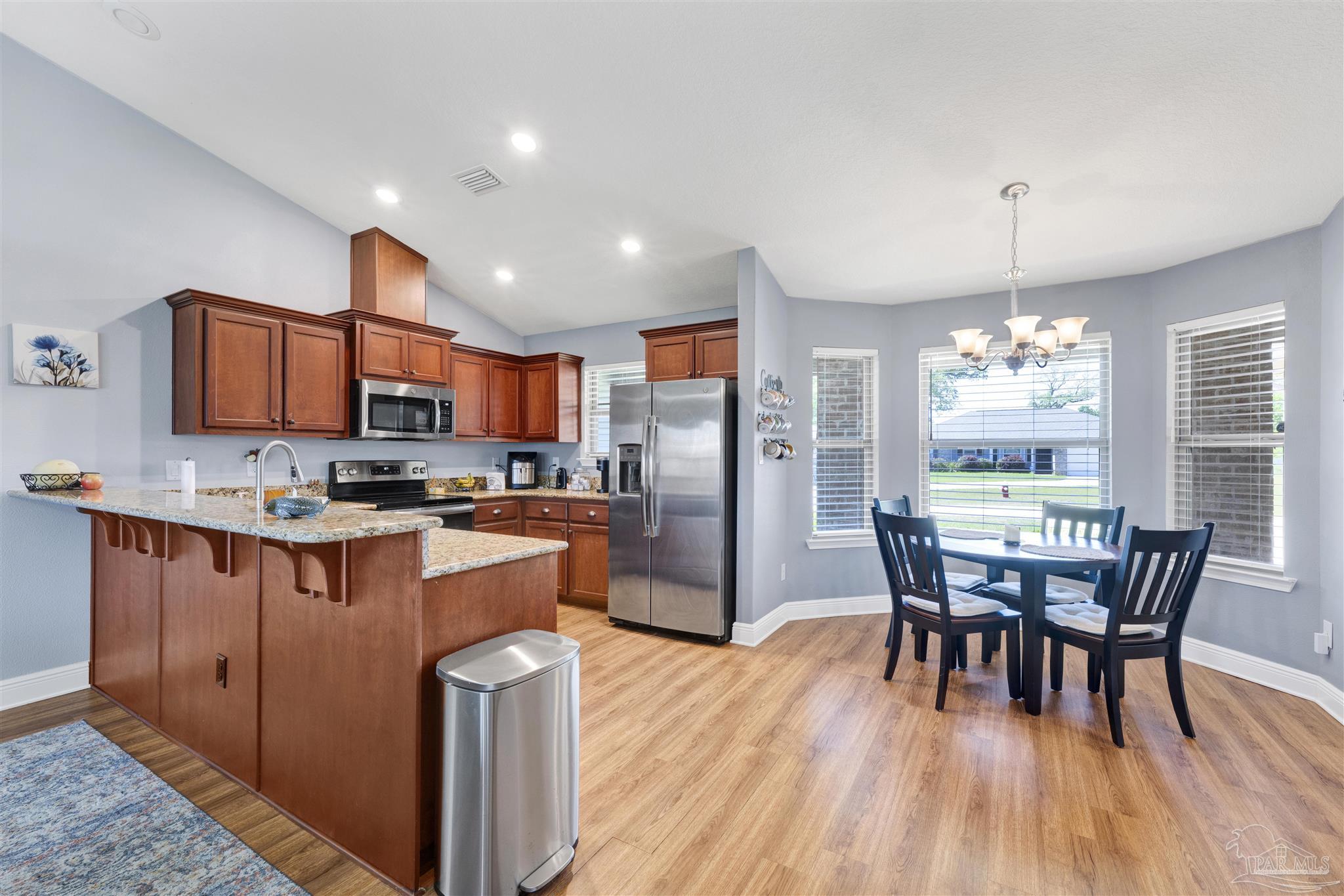 6336 Apple Ridge Circle Pensacola, FL 32526 - Photo 8 of 41 a kitchen with stainless steel appliances granite countertop a stove a refrigerator a kitchen island a dining table and chairs