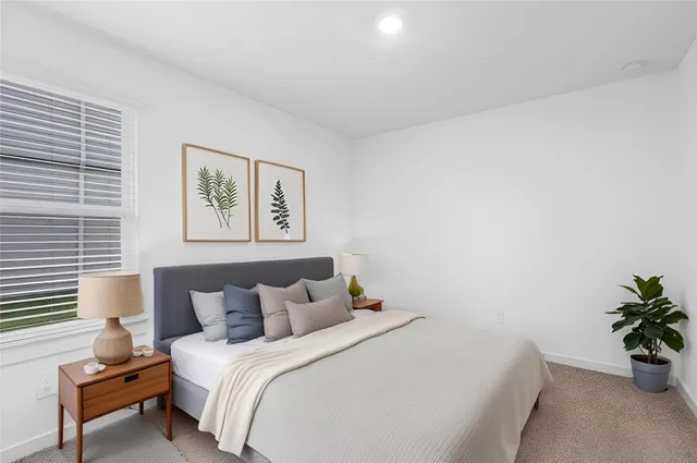 a bedroom with bed and paintings on the wall