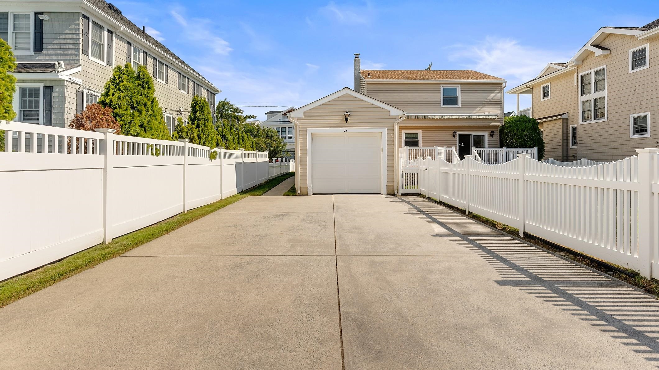 74 Walnut Road Ocean City, NJ 08226 - Photo 19 of 35 a view of a white house with a small yard and wooden fence