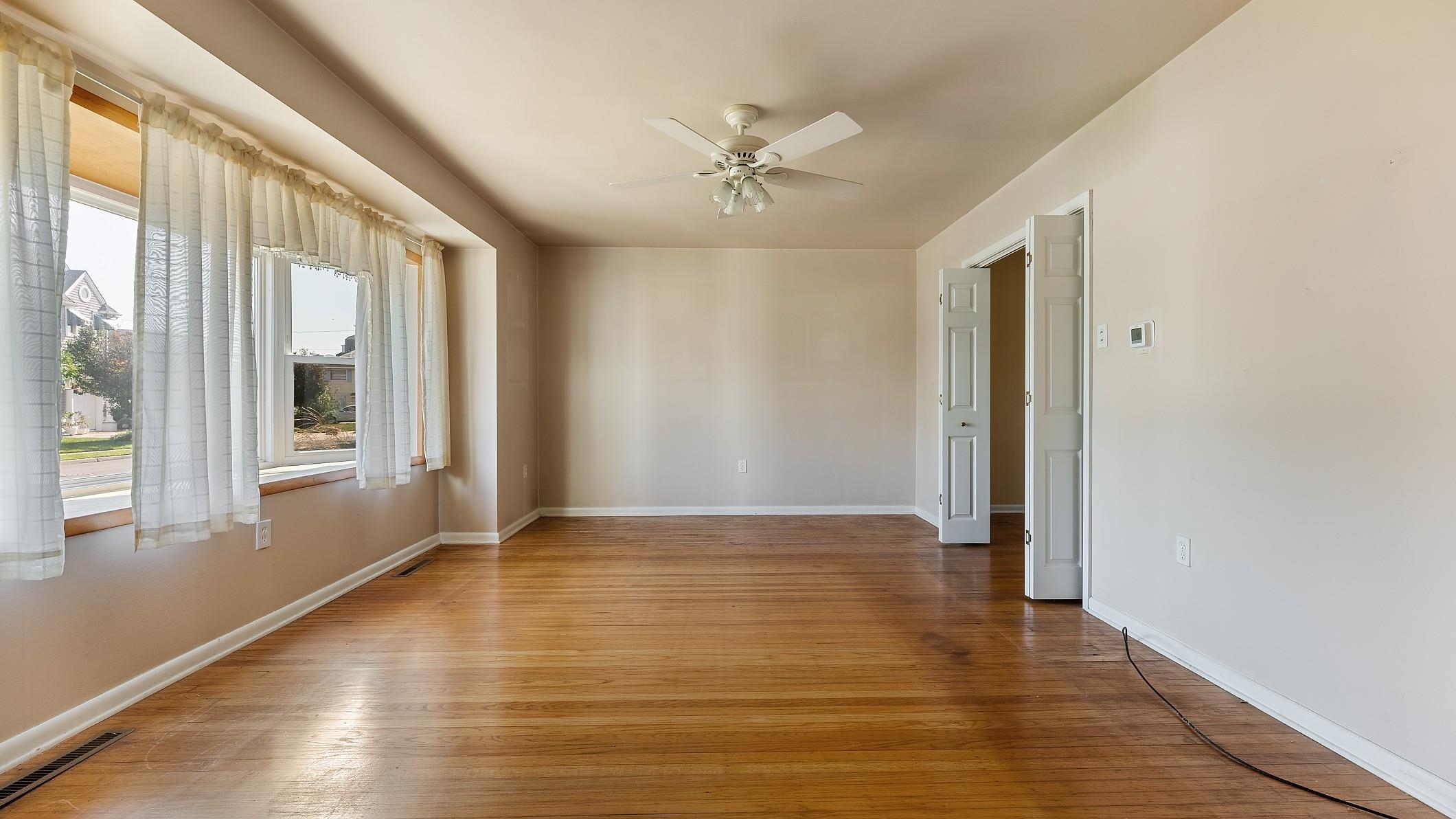 74 Walnut Road Ocean City, NJ 08226 - Photo 6 of 35 a view of an empty room with a window and wooden floor