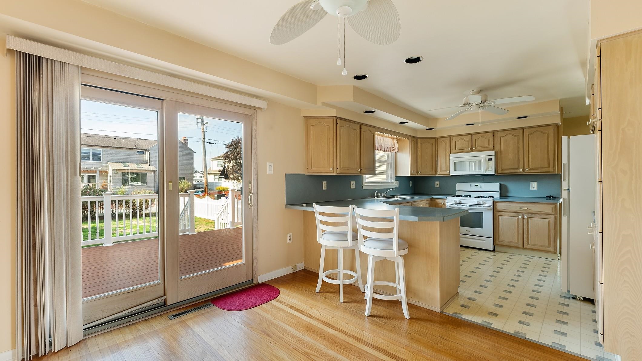 74 Walnut Road Ocean City, NJ 08226 - Photo 10 of 35 a kitchen with granite countertop a refrigerator and white cabinets