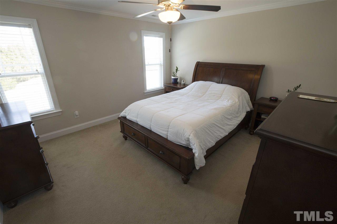 1309 Silver Farm Road Raleigh, NC 27603 - Photo 15 of 24 a bed sitting in a bedroom next to a window