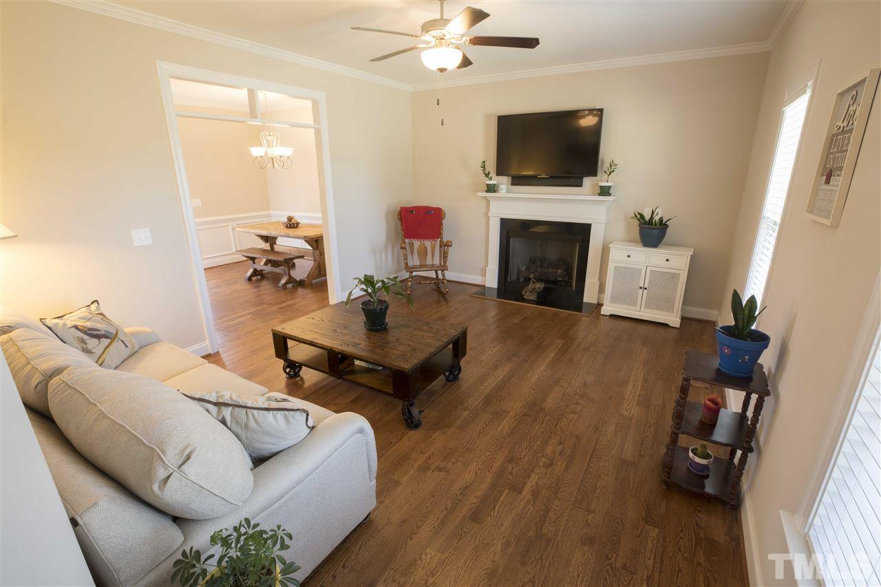 1309 Silver Farm Road Raleigh, NC 27603 - Photo 3 of 24 a living room with furniture a flat screen tv and a fireplace