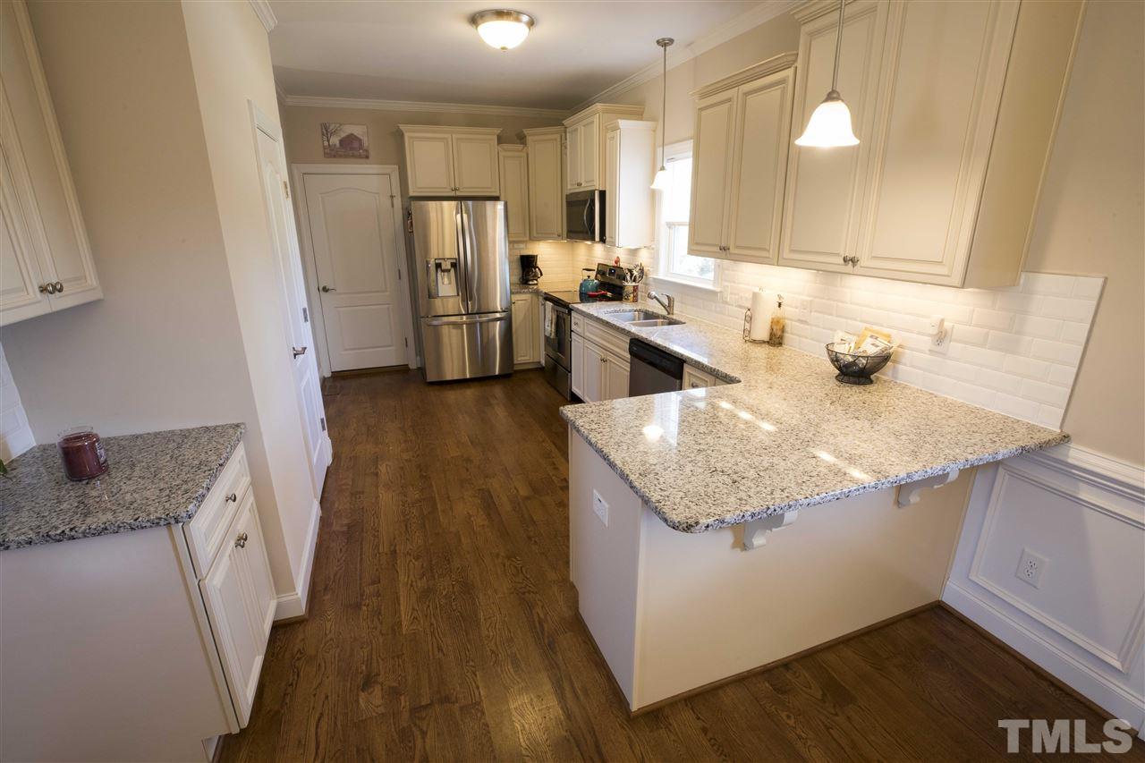 1309 Silver Farm Road Raleigh, NC 27603 - Photo 9 of 24 a kitchen with sink refrigerator and microwave