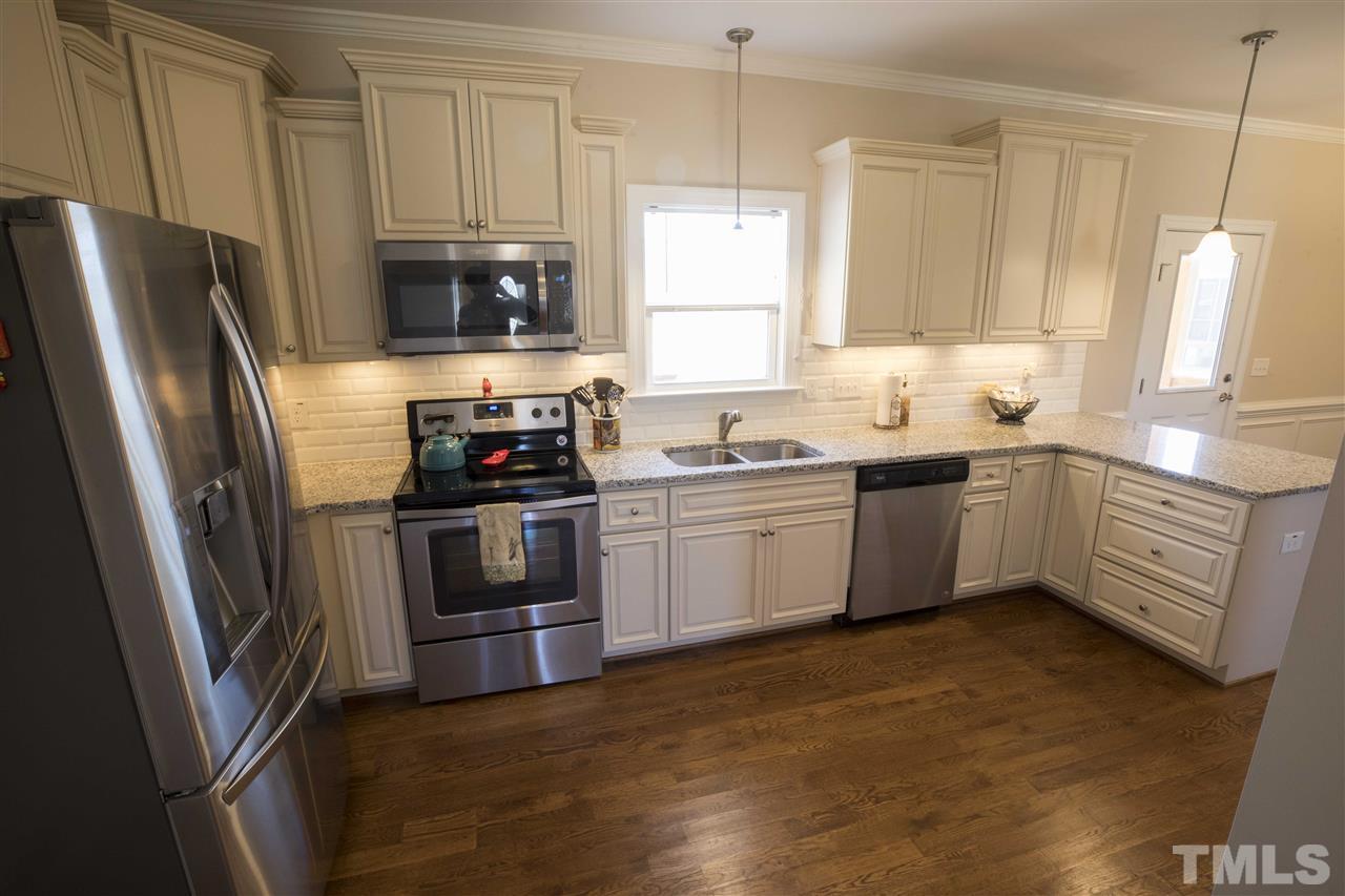 1309 Silver Farm Road Raleigh, NC 27603 - Photo 10 of 24 a kitchen with stainless steel appliances a stove a sink and a refrigerator