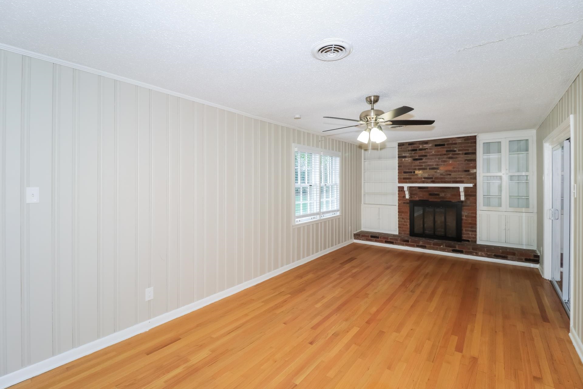 4947 Dee Road Memphis, TN 38117 - Photo 3 of 15 a view of an empty room with a fireplace and a window