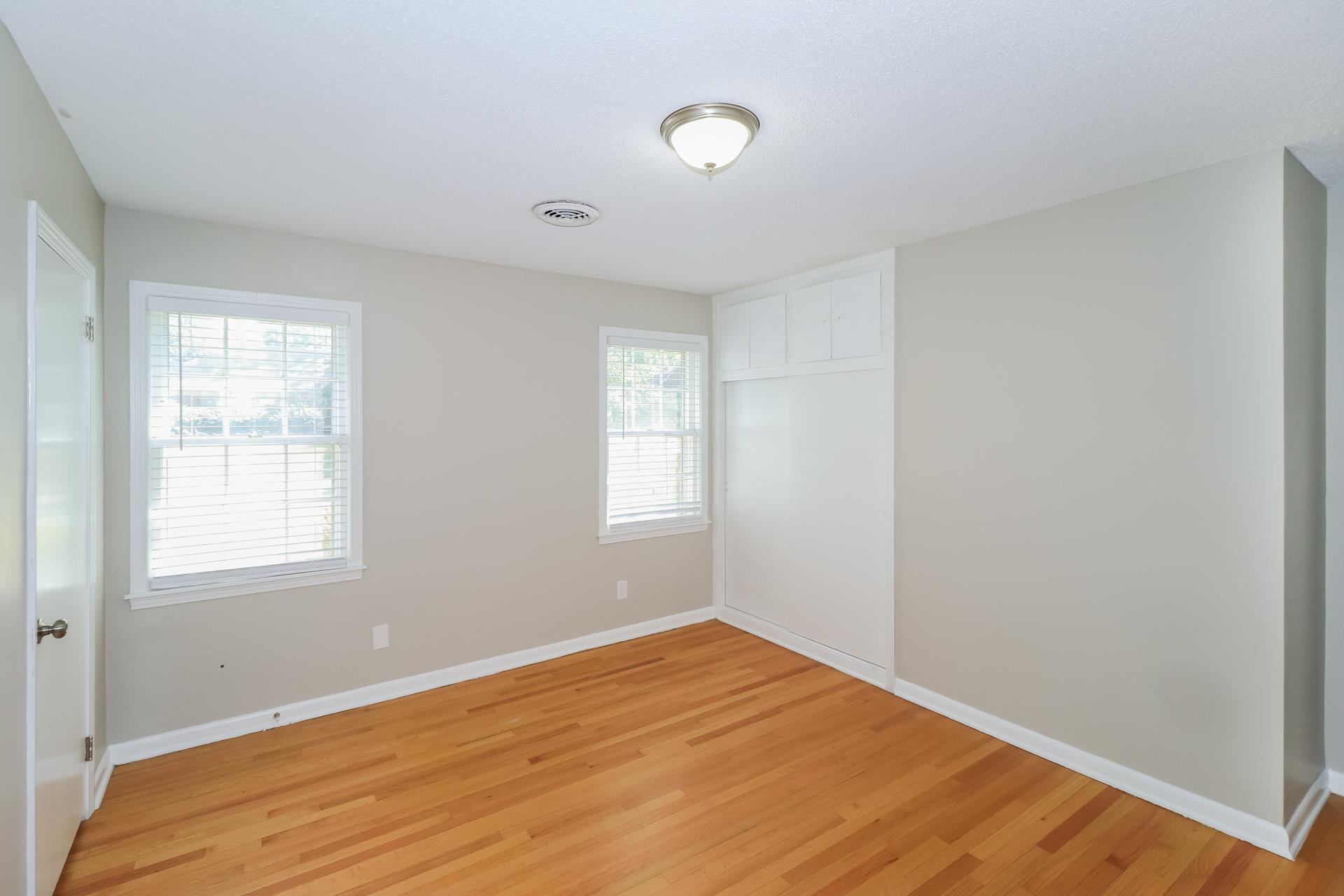 4947 Dee Road Memphis, TN 38117 - Photo 7 of 15 an empty room with wooden floor and windows