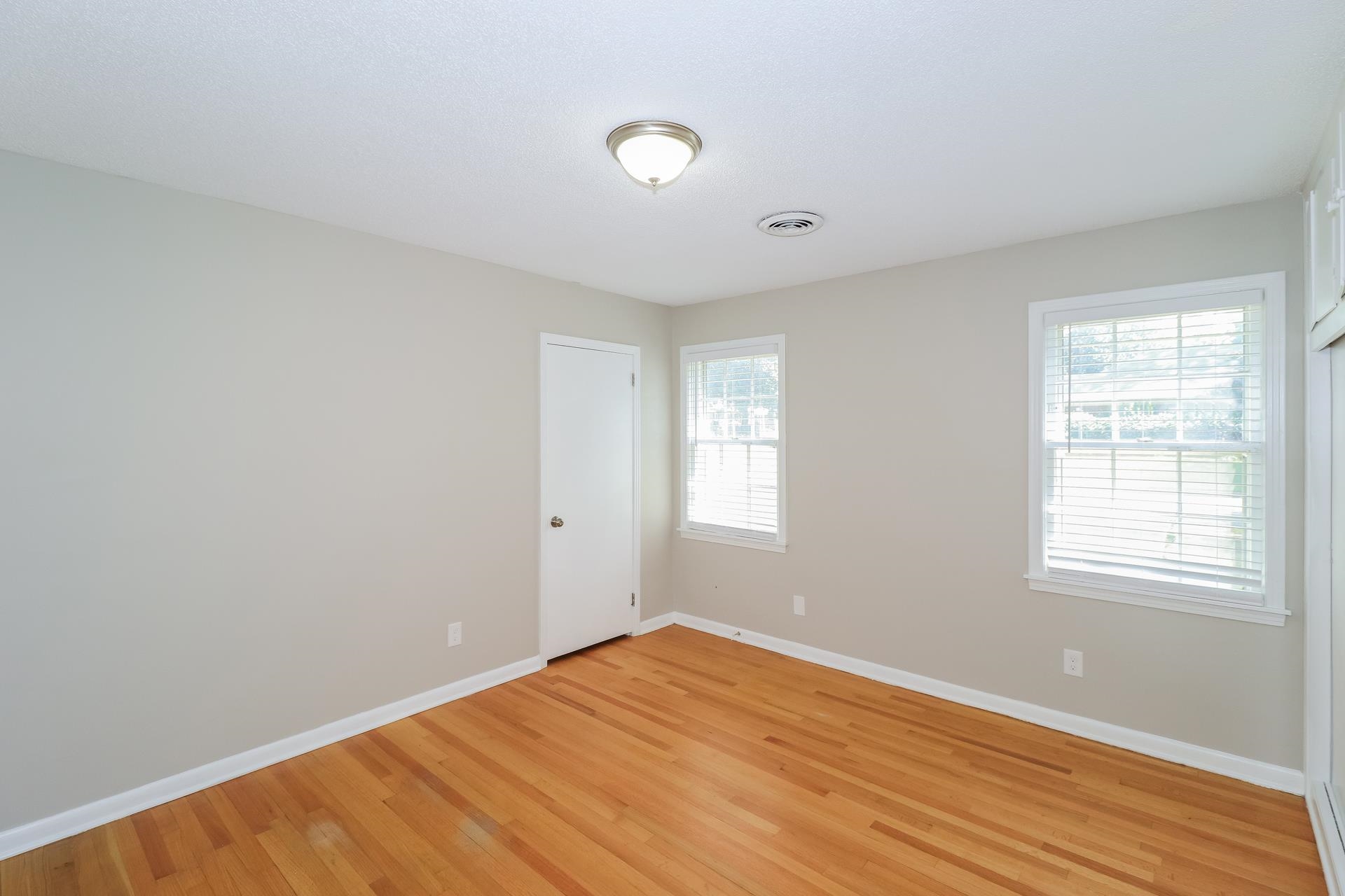 4947 Dee Road Memphis, TN 38117 - Photo 8 of 15 an empty room with wooden floor and windows