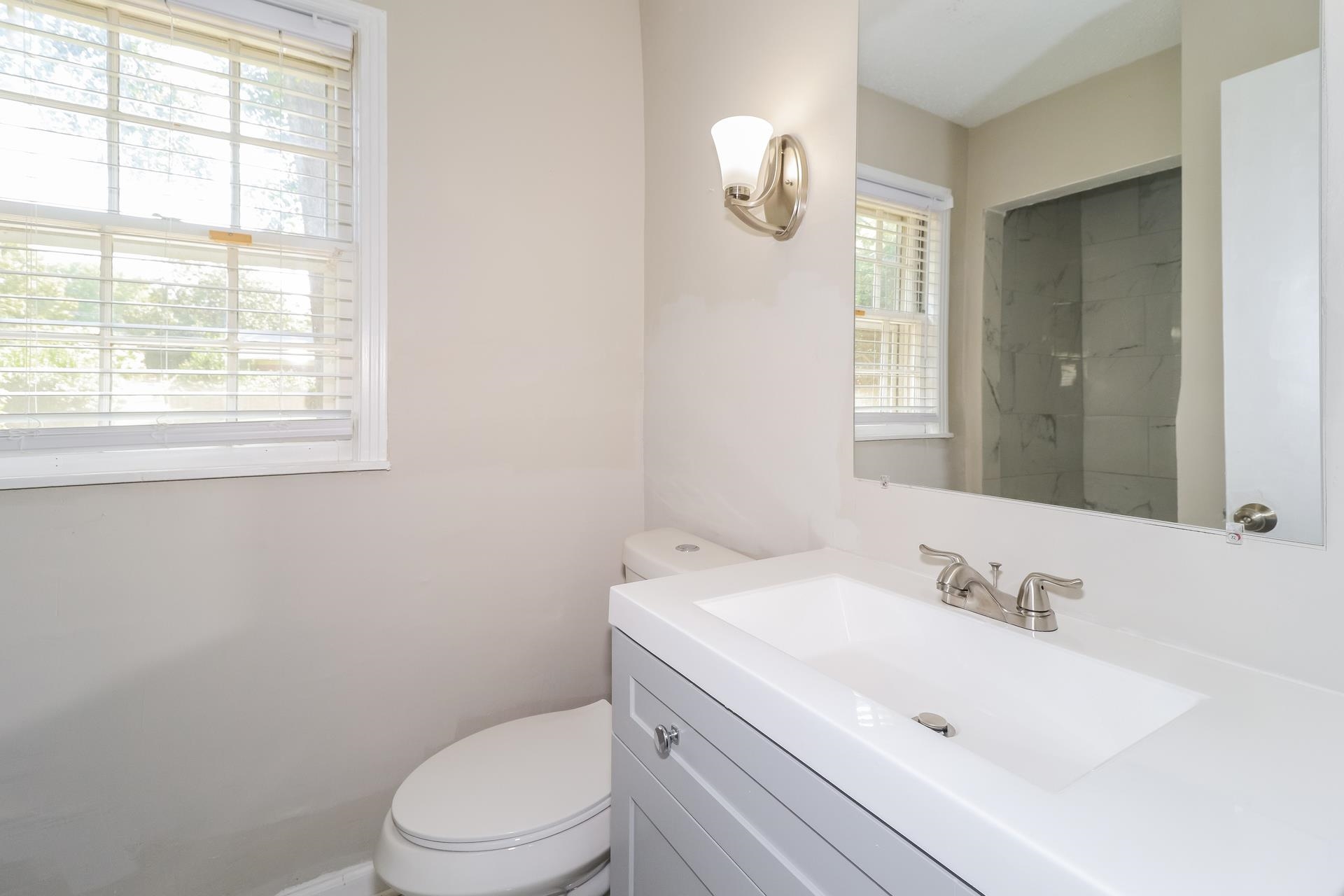 4947 Dee Road Memphis, TN 38117 - Photo 9 of 15 a bathroom with a sink a toilet and a window