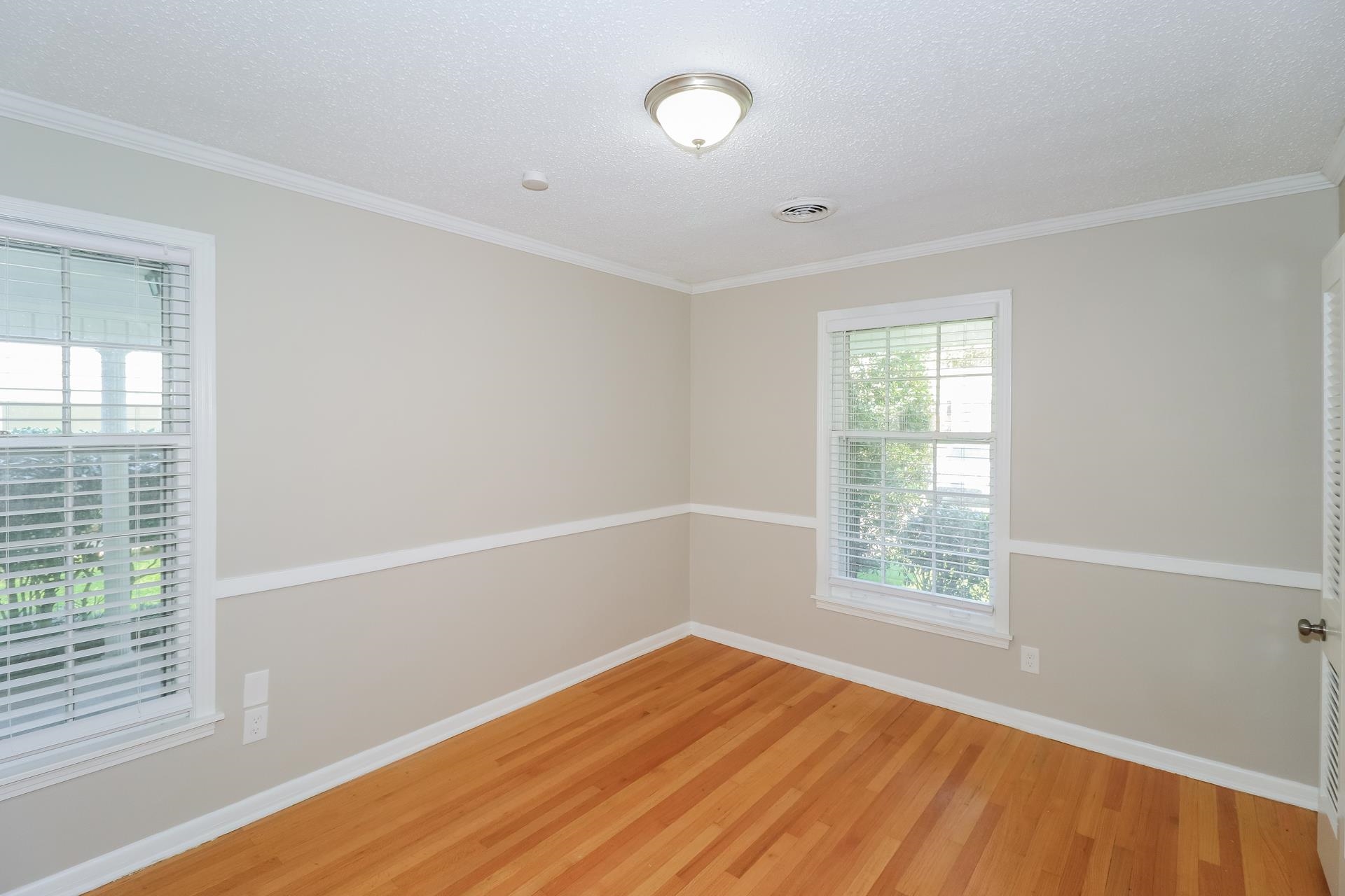 4947 Dee Road Memphis, TN 38117 - Photo 10 of 15 an empty room with wooden floor and windows