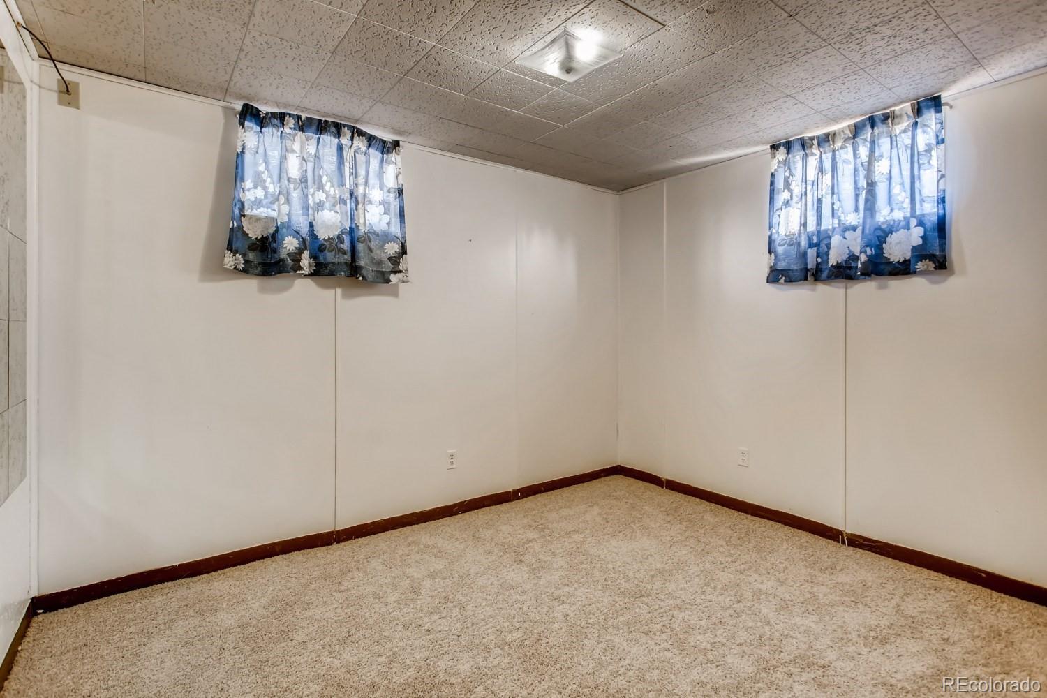 16060 Mt Vernon Road Golden, CO 80401 - Photo 23 of 29 an empty room with windows and chandelier fan