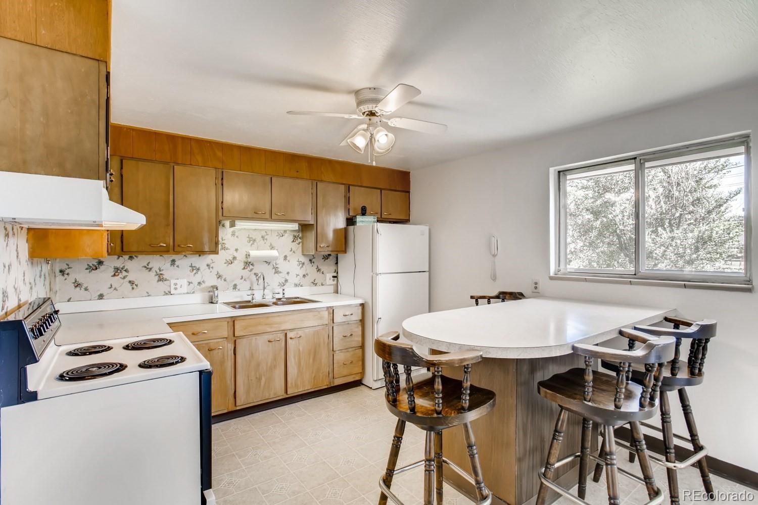 16060 Mt Vernon Road Golden, CO 80401 - Photo 7 of 29 a kitchen with kitchen island a stove a table and chairs in it
