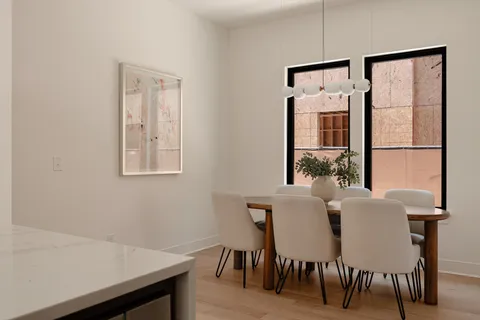 a kitchen with stainless steel appliances kitchen island granite countertop a table chairs and a refrigerator