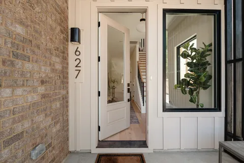 a kitchen with stainless steel appliances granite countertop a refrigerator a sink a stove and white cabinets with wooden floor