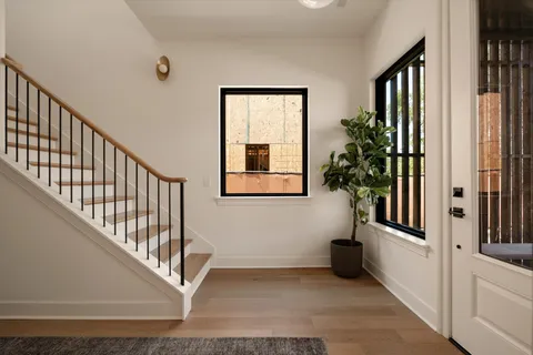 a kitchen with stainless steel appliances granite countertop a sink a stove and a wooden floor