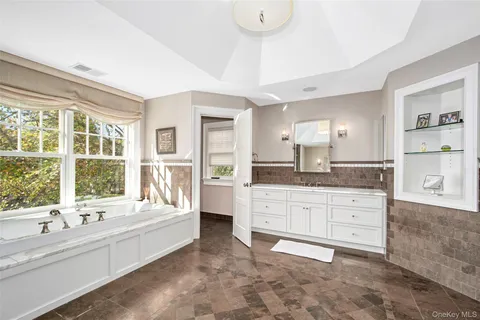 a large bathroom with a large tub sink and double vanity