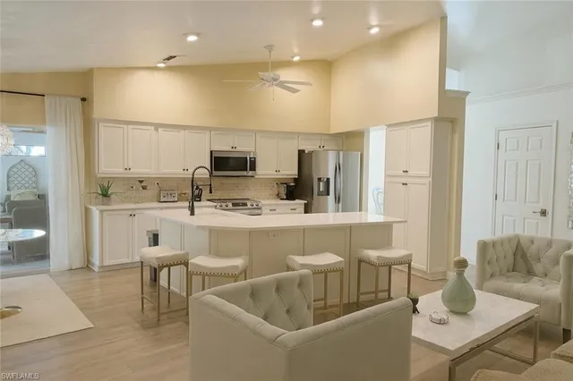 a kitchen with a sink and chairs